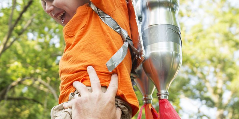 Papa steekt kind met oranje t-shirt omhoog - lidmaatschap aan verminderd tarief